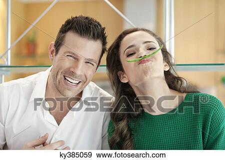 Couple playing with green bean in the kitchen View Large Photo Image Stock Photo - Couple playing with green bean in the kitchen. Fotosearch
