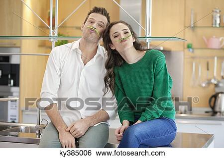Couple playing with green bean in the kitchen View Large Photo Image Stock Photograph - Couple playing with green bean in the kitchen. Fotosearch