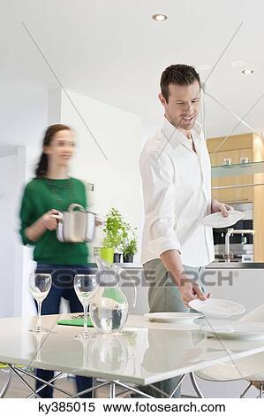 Stock Photography - Couple preparing to serve dinner. Fotosearch