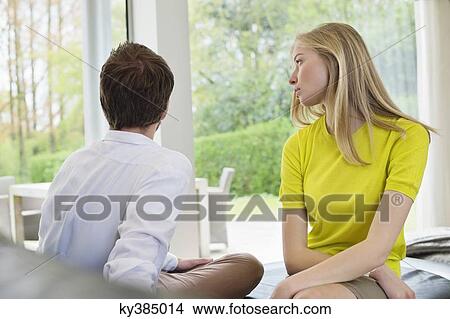 Picture - Couple sitting serious, man ignoring girlfriend. Fotosearch