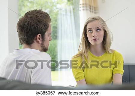 Couple sitting together, woman ignoring boyfriend View Large Photo Image Stock Photo - Couple sitting together, woman ignoring boyfriend. Fotosearch