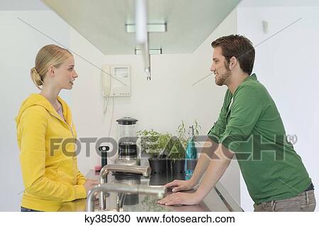 Couple talking across the kitchen counter View Large Photo Image Stock Image - Couple talking across the kitchen counter. Fotosearch