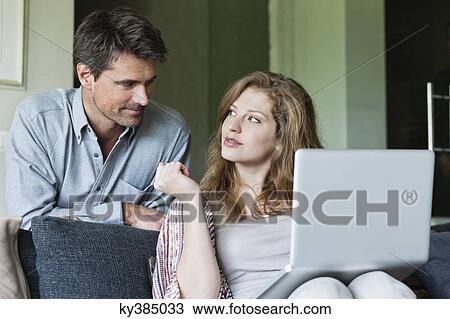 Stock Image - Couple using a laptop at home. Fotosearch