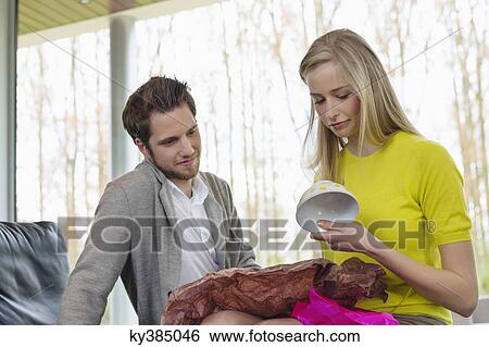 Happy woman looking at a present given by her boyfriend View Large Photo Image Stock Photograph - Happy woman looking at a present given by her boyfriend. Fotosearch