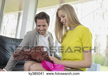 Happy woman opening a present given by her boyfriend View Large Photo Image Stock Image - Happy woman opening a present given by her boyfriend. Fotosearch