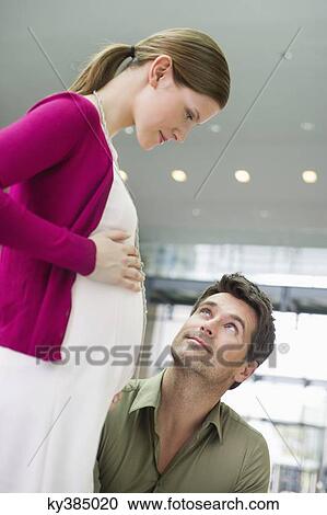 Man looking at a pregnant woman View Large Photo Image Stock Image - Man looking at a pregnant woman. Fotosearch