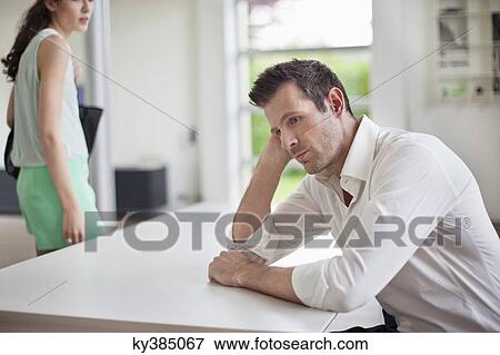 Man sitting at a table with a woman leaving the home View Large Photo Image Stock Photo - Man sitting at a table with a woman leaving the home. Fotosearch