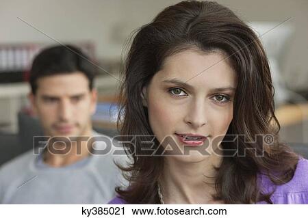 Portrait of a woman smiling with her husband in the background View Large Photo Image Stock Image - Portrait of a woman smiling with her husband in the background. Fotosearch