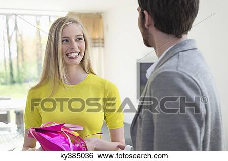 Stock Photograph - Woman receiving gift from boyfriend. Fotosearch