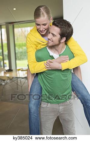 Woman riding piggyback on her boyfriend View Large Photo Image Picture - Woman riding piggyback on her boyfriend. Fotosearch