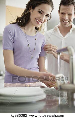 Woman washing utensils in the kitchen View Large Photo Image Stock Image - Woman washing utensils in the kitchen. Fotosearch