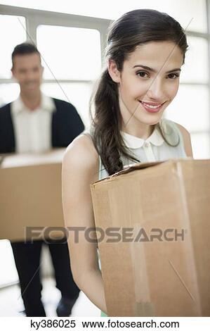 Couple carrying cardboard boxes at their new home View Large Photo Image Stock Photography - Couple carrying cardboard boxes at their new home. Fotosearch