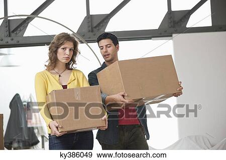 Couple carrying cardboard boxes View Large Photo Image Stock Photo - Couple carrying cardboard boxes. Fotosearch