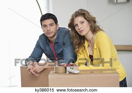 Couple leaning over cardboard boxes View Large Photo Image Stock Photography - Couple leaning over cardboard boxes. Fotosearch
