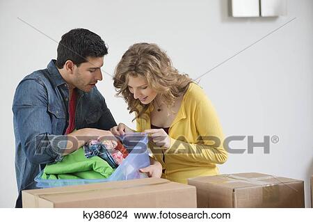 Couple looking into a laundry basket View Large Photo Image Picture - Couple looking into a laundry basket. Fotosearch