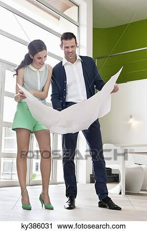 Couple reading a blueprint View Large Photo Image Stock Image - Couple reading a blueprint. Fotosearch