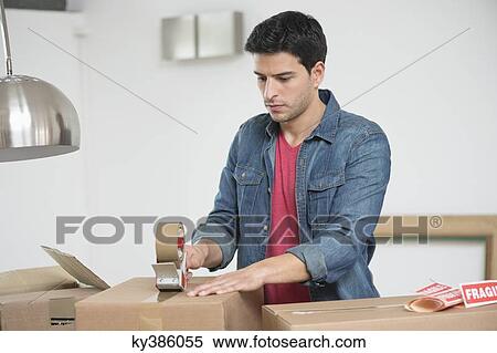 Stock Photography - Man taping up a cardboard box. Fotosearch