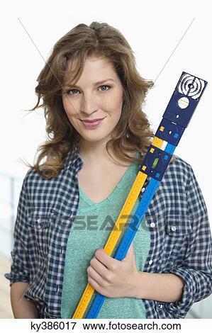 Portrait of a woman holding a level View Large Photo Image Stock Photo - Portrait of a woman holding a level. Fotosearch