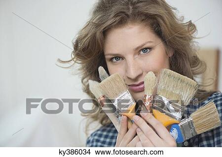 Portrait of a woman holding paintbrushes View Large Photo Image Picture - Portrait of a woman holding paintbrushes. Fotosearch