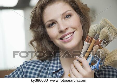 Portrait of a woman holding paintbrushes View Large Photo Image Stock Image - Portrait of a woman holding paintbrushes. Fotosearch