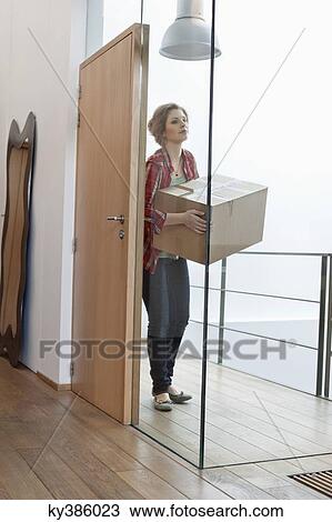 Woman carrying a cardboard box at home View Large Photo Image Stock Image - Woman carrying a cardboard box at home. Fotosearch