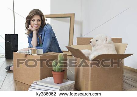Woman leaning on a cardboard box and looking at a teddy bear View Large Photo Image Stock Image - Woman leaning on a cardboard box and looking at a teddy bear. Fotosearch