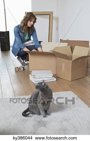 Woman putting books in a cardboard box View Large Photo Image Picture - Woman putting books in a cardboard box. Fotosearch