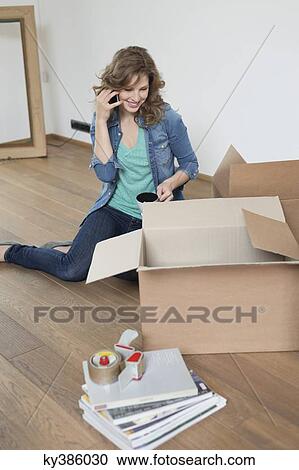 Woman talking on a mobile phone near cardboard boxes View Large Photo Image Stock Image - Woman talking on a mobile phone near cardboard boxes. Fotosearch
