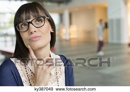 Stock Photo - Close-up of a businesswoman day dreaming. Fotosearch