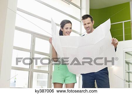 Stock Photograph - Couple reading a blueprint. Fotosearch