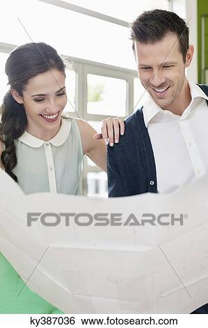 Stock Photograph - Couple reading a blueprint. Fotosearch