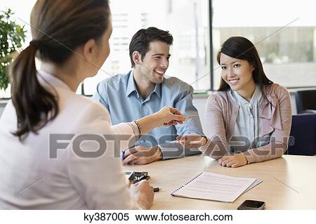 Stock Photography - Couple receiving keys from real estate agent. Fotosearch