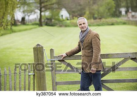 Portrait of a man standing in a park View Large Photo Image Picture - Portrait of a man standing in a park. Fotosearch