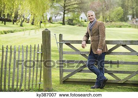 Portrait of a man standing in a park View Large Photo Image Stock Photo - Portrait of a man standing in a park. Fotosearch