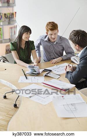 Real estate agent discussing property documents to his clients View Large Photo Image Stock Image - Real estate agent discussing property documents to his clients. Fotosearch