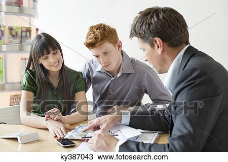 Real estate agent discussing property documents to his clients View Large Photo Image Stock Image - Real estate agent discussing property documents to his clients. Fotosearch