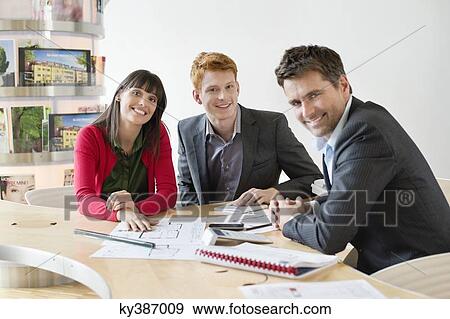 Real estate agent discussing property documents to his clients View Large Photo Image Stock Photo - Real estate agent discussing property documents to his clients. Fotosearch