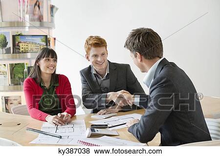 Real estate agent discussing property documents to his clients View Large Photo Image Stock Photo - Real estate agent discussing property documents to his clients. Fotosearch