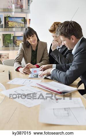 Real estate agent discussing property documents to his clients View Large Photo Image Stock Photography - Real estate agent discussing property documents to his clients. Fotosearch