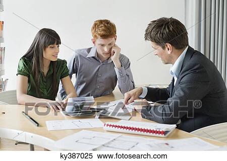 Stock Photography - Real estate agent discussing property documents to his clients. Fotosearch