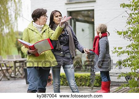 Real estate agent showing woman a house View Large Photo Image Picture - Real estate agent showing woman a house. Fotosearch
