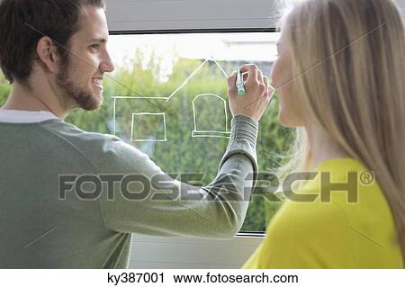 Woman looking at an architect drawing a design on the window glass View Large Photo Image Stock Image - Woman looking at an architect drawing a design on the window glass. Fotosearch