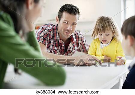 Couple teaching their children at home View Large Photo Image Picture - Couple teaching their children at home. Fotosearch