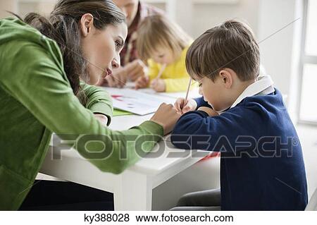 Couple teaching their children at home View Large Photo Image Stock Photo - Couple teaching their children at home. Fotosearch