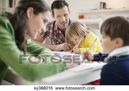 Couple teaching their children at home View Large Photo Image Stock Photograph - Couple teaching their children at home. Fotosearch