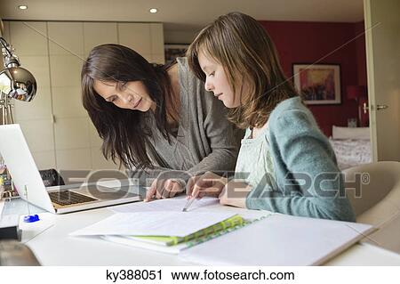 Girl studying with her mother at home View Large Photo Image Stock Image - Girl studying with her mother at home. Fotosearch