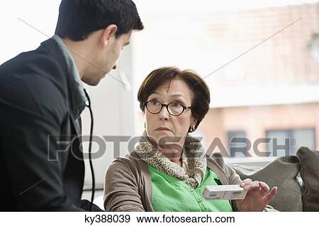 Stock Photo - Male doctor giving medicine to a patient. Fotosearch