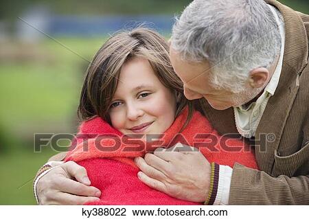 Man hugging his daughter in a park View Large Photo Image Stock Image - Man hugging his daughter in a park. Fotosearch