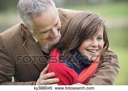 Man hugging his daughter in a park View Large Photo Image Stock Photography - Man hugging his daughter in a park. Fotosearch
