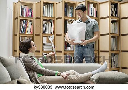 Man talking to his mother reclining on a couch View Large Photo Image Stock Image - Man talking to his mother reclining on a couch. Fotosearch